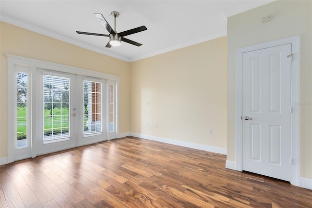 empty room featuring ceiling fan, dark wood-type flooring, ornamental molding, and french doors