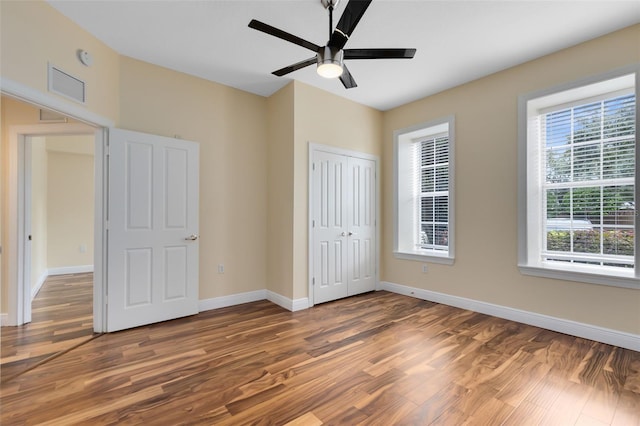 unfurnished bedroom with a closet, ceiling fan, and dark hardwood / wood-style floors