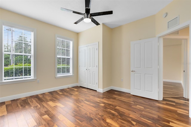 unfurnished bedroom featuring ceiling fan and dark hardwood / wood-style flooring