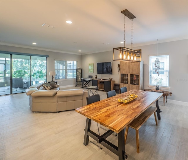 dining space featuring light hardwood / wood-style flooring and ornamental molding