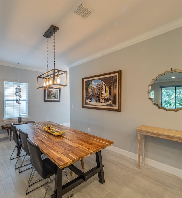 dining area featuring crown molding, a wealth of natural light, and light hardwood / wood-style floors