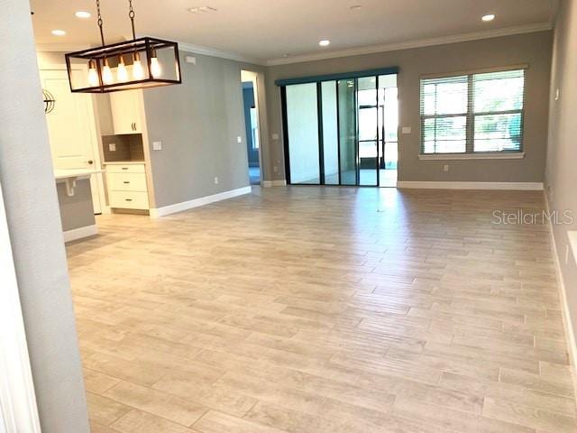 spare room featuring crown molding and light hardwood / wood-style flooring