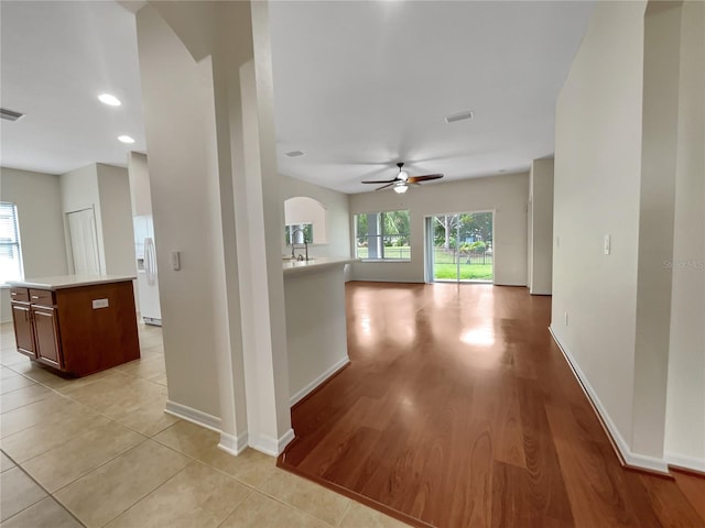 hall featuring sink and light tile patterned flooring