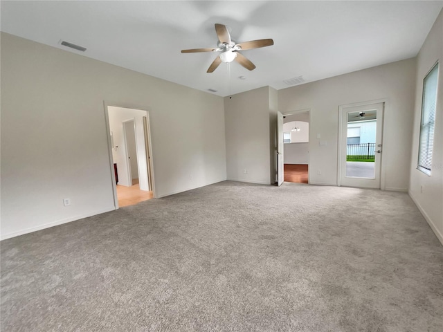 unfurnished living room featuring ceiling fan and carpet