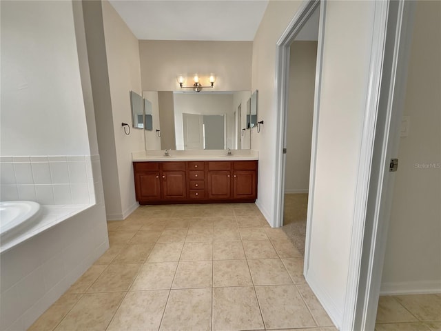 bathroom featuring tiled bath, vanity, and tile patterned flooring