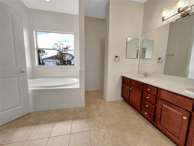 bathroom with vanity, tile patterned flooring, and tiled tub