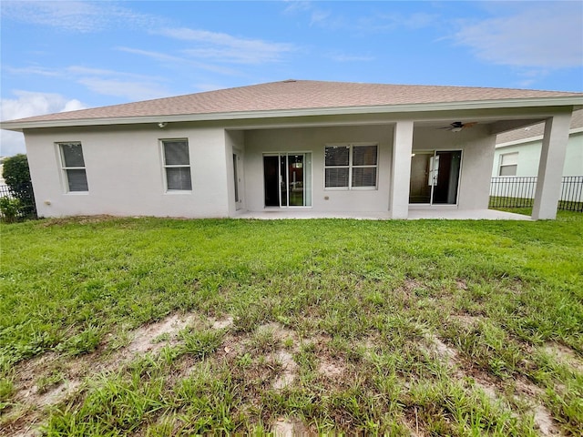 back of property with ceiling fan, a yard, and a patio