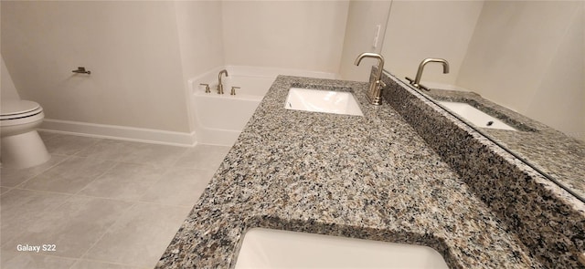 bathroom featuring tile patterned flooring, vanity, a washtub, and toilet