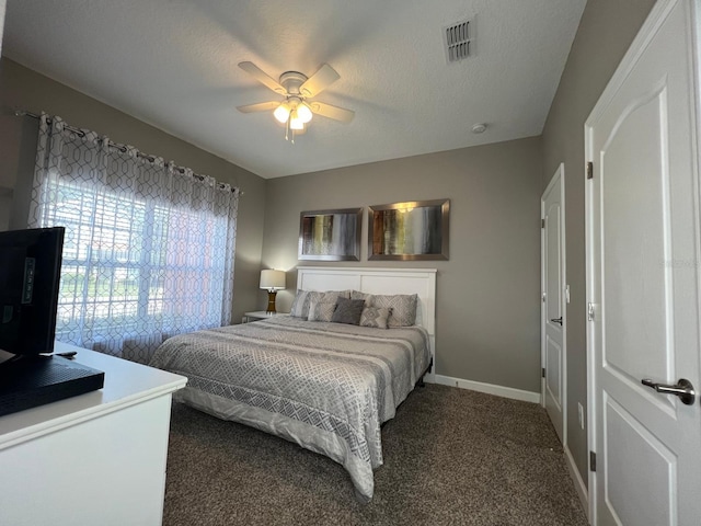 carpeted bedroom with ceiling fan and a textured ceiling