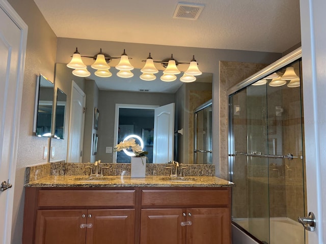 bathroom featuring vanity and shower / bath combination with glass door