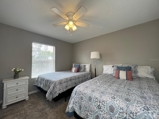 bedroom featuring ceiling fan and dark carpet