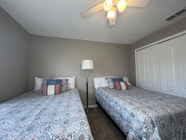 carpeted bedroom with a textured ceiling, a closet, and ceiling fan