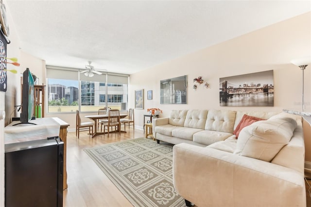 living room featuring a textured ceiling, hardwood / wood-style floors, and ceiling fan