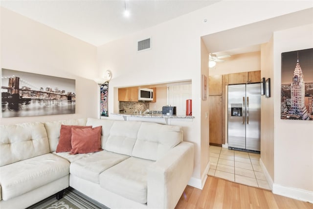 living room with light hardwood / wood-style flooring and ceiling fan