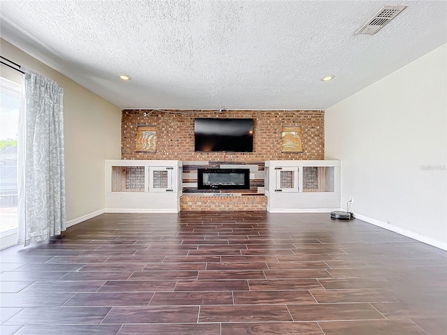 unfurnished living room with a fireplace and a textured ceiling