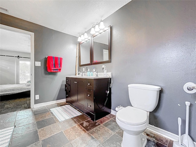 bathroom featuring vanity, toilet, and a textured ceiling