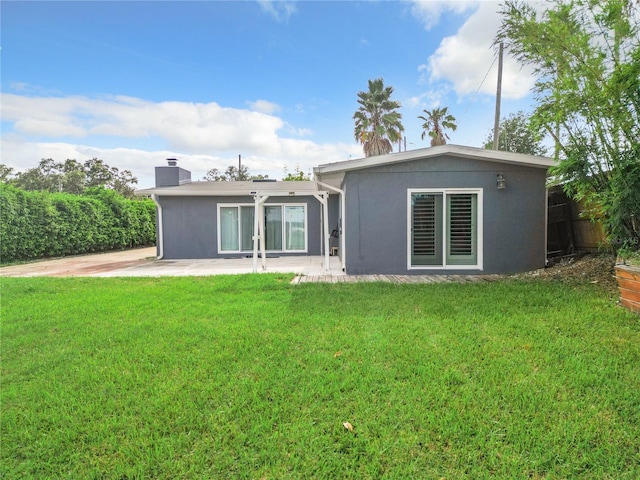 back of property with a patio area and a yard