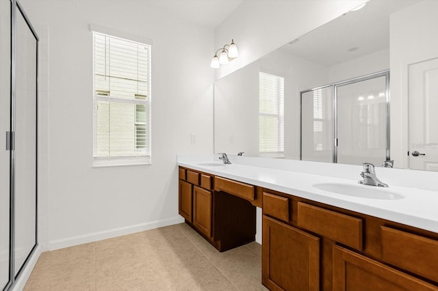 bathroom featuring dual vanity, a shower with door, plenty of natural light, and tile patterned floors