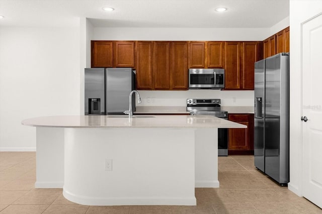 kitchen featuring light tile patterned floors, stainless steel appliances, sink, and a center island with sink