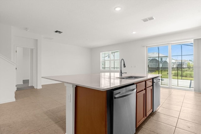 kitchen with light tile patterned flooring, dishwasher, sink, and a center island with sink