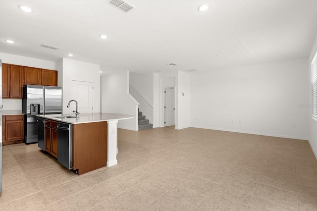 kitchen featuring light tile patterned flooring, sink, a kitchen island with sink, and stainless steel appliances