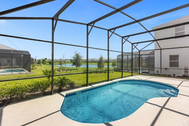 view of pool with a lawn, a patio area, and a lanai