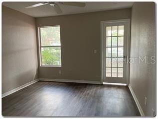 unfurnished room with ceiling fan and dark hardwood / wood-style floors