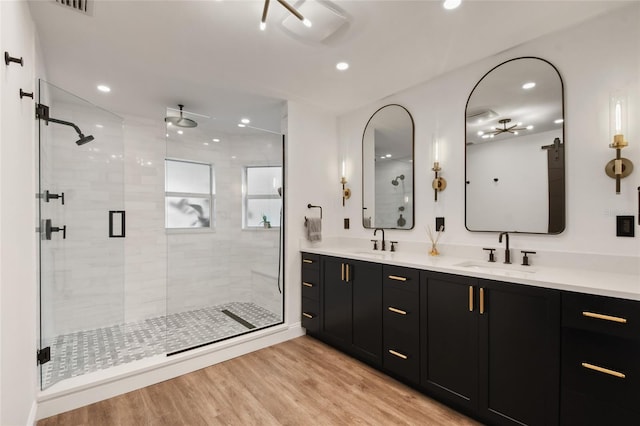 bathroom with hardwood / wood-style flooring, vanity, and a shower with shower door