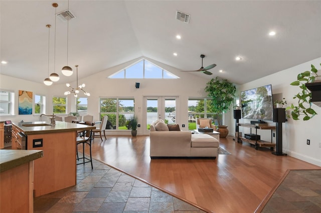 living room with hardwood / wood-style flooring, sink, ceiling fan with notable chandelier, and high vaulted ceiling