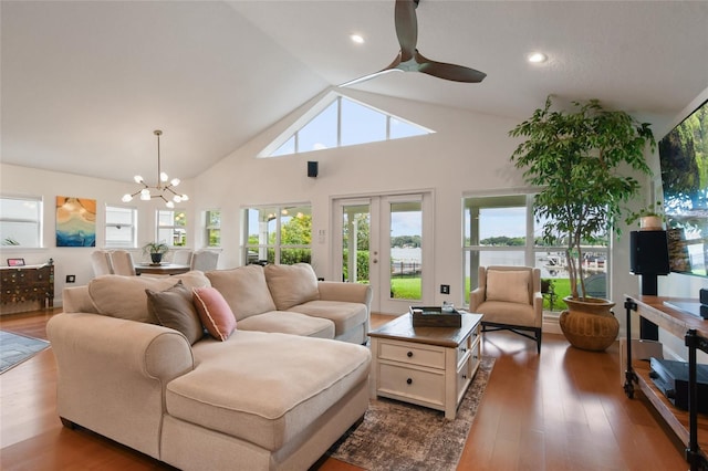 living room featuring hardwood / wood-style flooring, ceiling fan with notable chandelier, and high vaulted ceiling