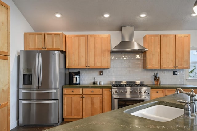 kitchen with wall chimney exhaust hood, stainless steel appliances, sink, and backsplash