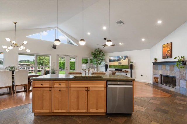 kitchen with sink, a tile fireplace, hanging light fixtures, and a kitchen island