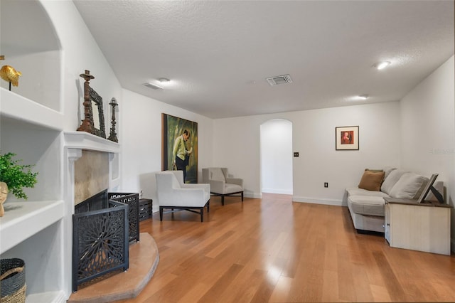 living room featuring a textured ceiling and light hardwood / wood-style floors