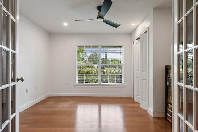 empty room with hardwood / wood-style flooring, ceiling fan, and french doors