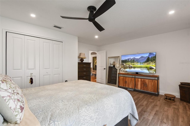 bedroom with ceiling fan, dark hardwood / wood-style flooring, and a closet