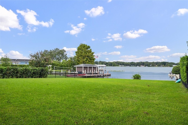 view of dock featuring a water view and a yard