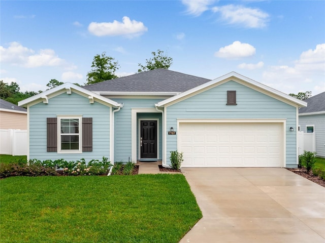 ranch-style home featuring a garage and a front lawn