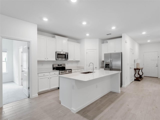 kitchen with white cabinetry, sink, a center island with sink, and appliances with stainless steel finishes