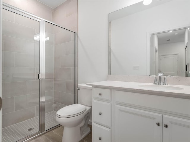 bathroom with tile patterned flooring, vanity, toilet, and walk in shower