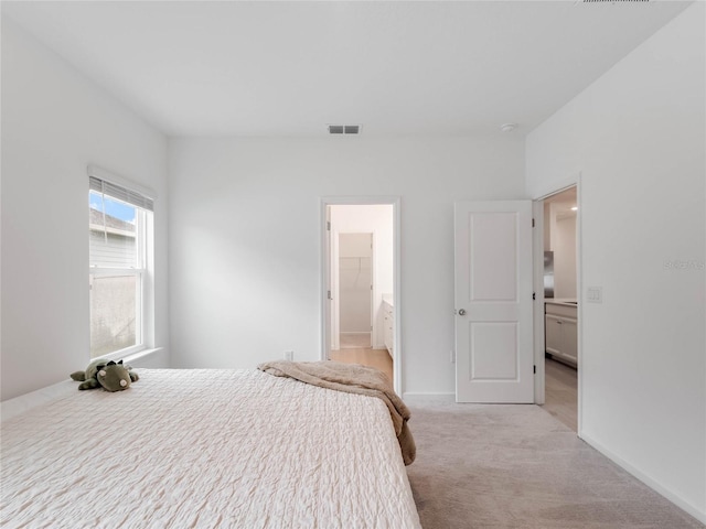 carpeted bedroom featuring a walk in closet and a closet