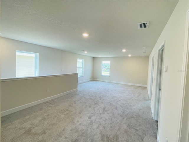 carpeted empty room with a textured ceiling