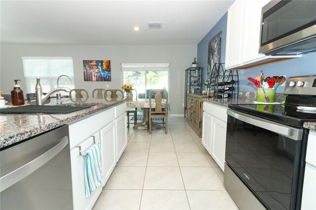 kitchen featuring white cabinetry, stone countertops, and stainless steel appliances