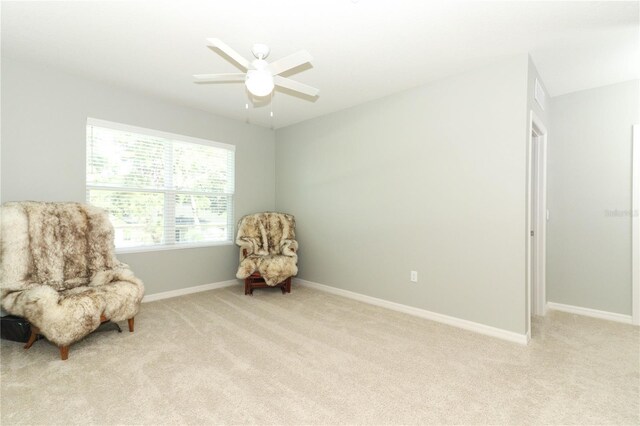 living area with ceiling fan and light colored carpet