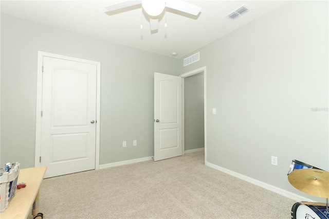 unfurnished bedroom featuring ceiling fan and light colored carpet