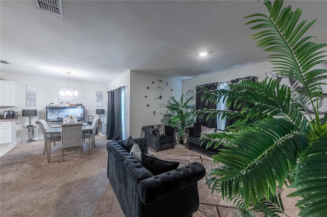 carpeted living room featuring a textured ceiling and a chandelier