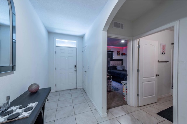 tiled foyer with a textured ceiling