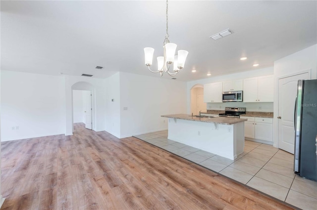 2950 Gibraltar Blvd, New Smyrna Beach, FL 32168 - kitchen featuring visible vents, a sink, arched walkways, light wood-style floors, and appliances with stainless steel finishes