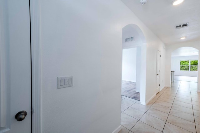 2950 Gibraltar Blvd, New Smyrna Beach, FL 32168 - hallway with arched walkways, visible vents, baseboards, and light tile patterned floors