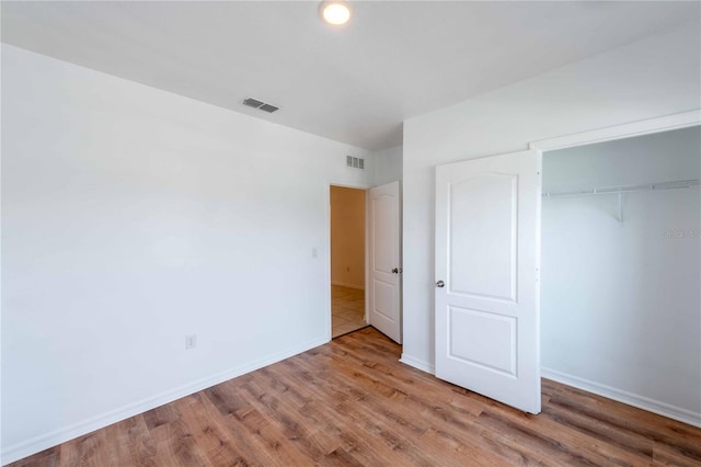 2950 Gibraltar Blvd, New Smyrna Beach, FL 32168 - unfurnished bedroom featuring baseboards, wood finished floors, visible vents, and a closet