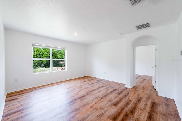 2950 Gibraltar Blvd, New Smyrna Beach, FL 32168 - unfurnished room with arched walkways, light wood-style flooring, visible vents, and baseboards